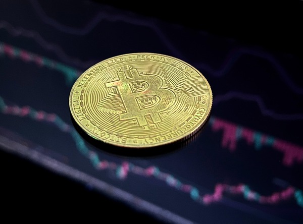 Golden Bitcoin coin above falling market lines