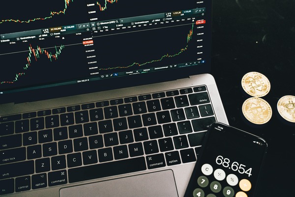 Laptop with charts, a calculator and coins