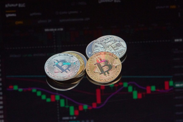 Stack of crypto coins on a candlestick chart