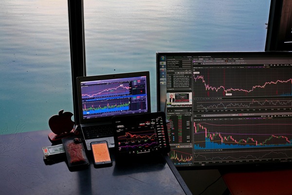 Trading monitors by a window overlooking the sea